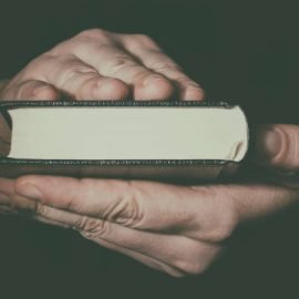 Hand with Holy Bible book. Freedom of religion concept.